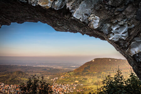 Blick von der Burgruine Hohenneuffen über die Berge der Schwäbischen Alb. EIngerahmt ist das Bild durch einen Mauerbogen