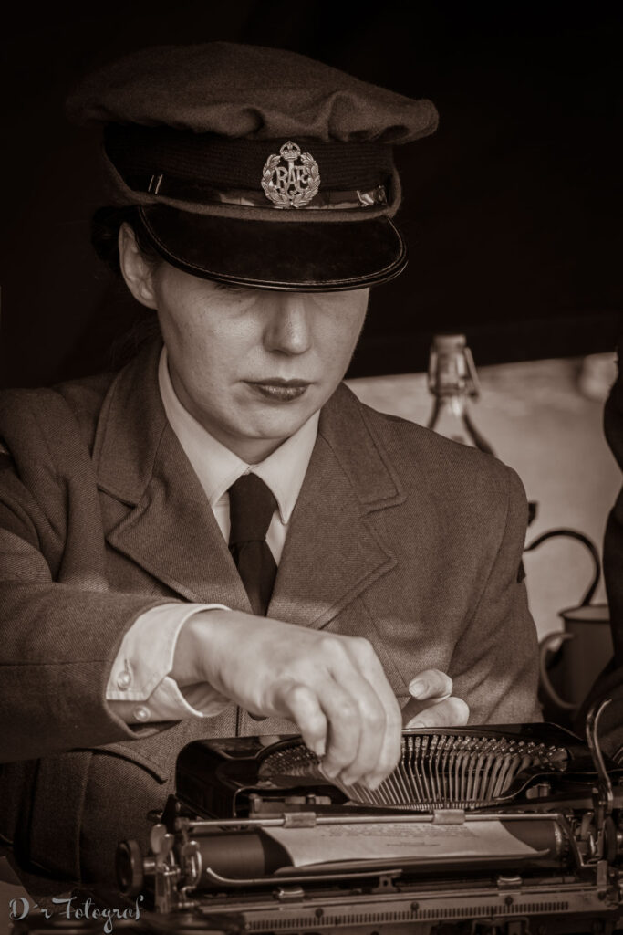 Frau in Uniform mit Mütze der Royal Air Force tippt auf einer Schreibmaschine